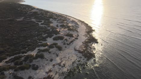 Drohnenantenne,-Die-Sich-Bei-Sonnenuntergang-Rückwärts-über-Die-Küste-Des-Exmouth-Ningaloo-Reef-Bewegt