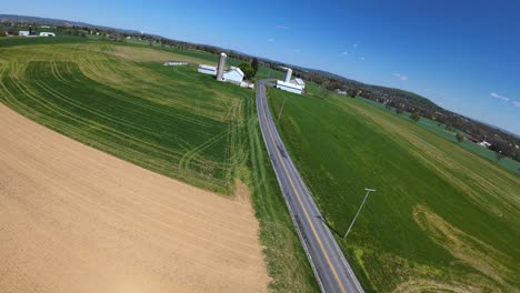 Vuelo-De-Drones-Sobre-Calles-En-Zonas-Rurales-Con-Campos-Agrícolas