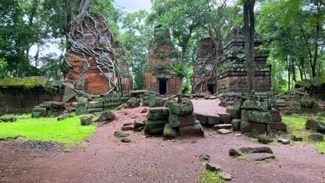 Revealing-shot-of-the-lonely-Prasat-Kraham-towers,-historical-and-touristic-site-of-Cambodia