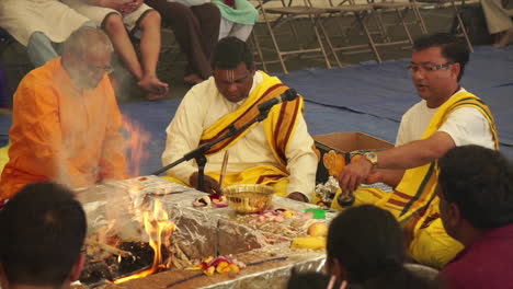 Hindu-priests-and-celebrants-toss-offerings-into-a-ritual-fire-in-unison