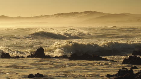 Rough-Sea-Waves-Crashing-On-Rocky-Shoreline-During-Golden-Afternoon---Wide-Static-Shot