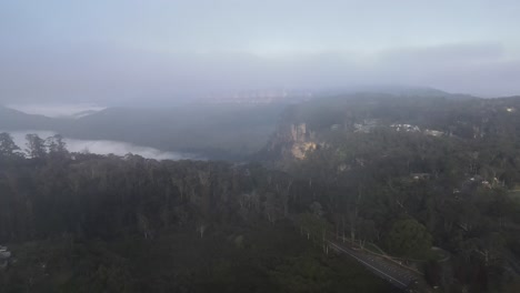 Antena-De-Drones-Avanzando-A-Través-De-Las-Nubes-Mostrando-Las-Montañas-Azules-En-Una-Mañana-Nublada