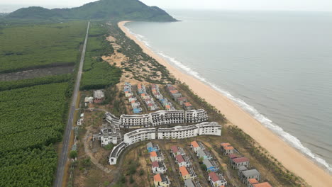 Slow-Motion-Drone-Rise-Track-Back-Over-Abandoned-Hotel-Complex-In-Lang-Co-Vietnam