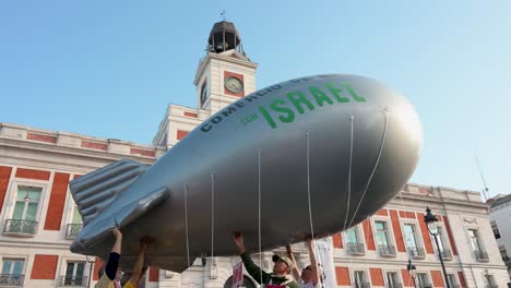 Manifestantes-Pro-Palestinos-Se-Reúnen-En-La-Puerta-Del-Sol-En-Madrid,-España,-Exigiendo-El-Fin-De-La-Venta-De-Armas-A-Israel,-Y-Algunos-Sostienen-Un-Globo-Que-Representa-Una-Bomba-En-Solidaridad.