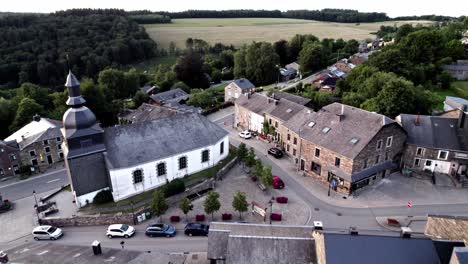 Approach-aerial-towards-church-in-small-idyllic-village-in-Belgium-Ardennes