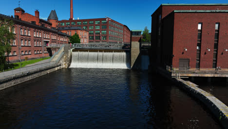 Drone-tilting-toward-the-Tammerkoski-dam,-sunny,-summer-day-in-Tampere,-Finland