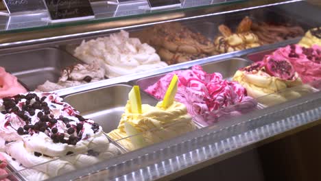Freezer-display-case-of-several-varieties-of-gourmet-ice-cream-on-sale-in-ice-cream-shop