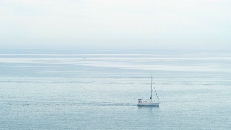 Sailboat-sailing-peacefully-through-the-calm-waters-of-the-sea-on-a-cloudy-day