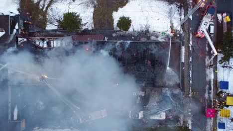 Feuerwehrleute-Bekämpfen-Einen-Schulbrand-In-Montreal,-Rauch-Steigt-Auf,-Die-Dämmerung-Bricht-Herein,-Notfallmaßnahmen-Im-Einsatz,-Luftaufnahme