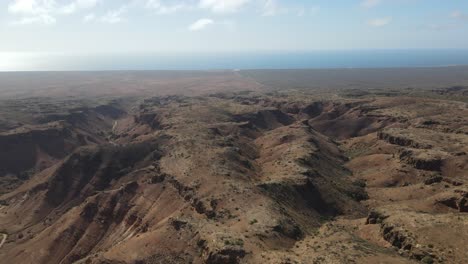 Drone-aerial-pan-right-over-the-ridges-of-the-Charles-knife-gorge-with-the-landscape-and-clouds