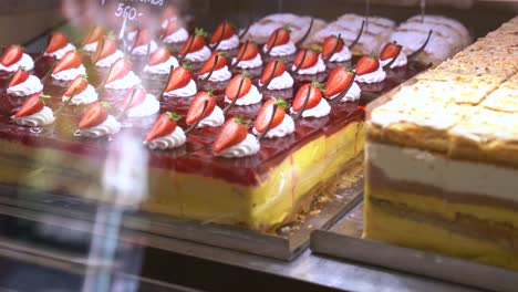 Decadent-strawberry-cake-on-display-in-glass-case-in-gourmet-dessert-shop