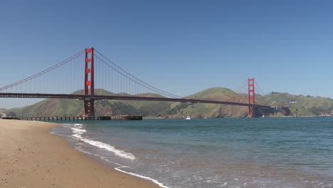 Golden-Gate-Bridge-with-Blue-Skies-and-Calm-Beach-Waters-Across-the-Bay-of-San-Francisco,-California,-USA