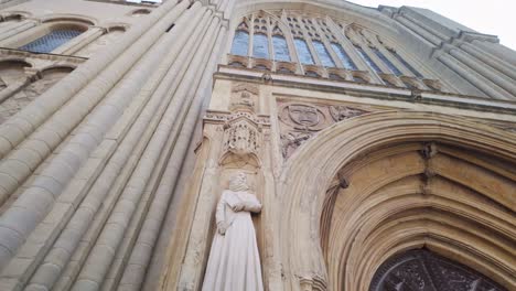 Looking-at-the-stone-sculptures-figure,-entrance-to-Norwich-cathedral