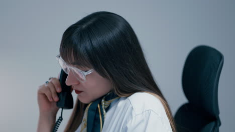 Beautiful-young-woman-with-long-dark-hair-wearing-glasses-talking-on-the-phone-with-a-client-and-hanging-up-in-slow-motion