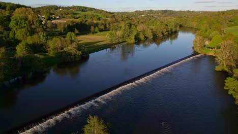 Drone-flying-over-Vienne-river-in-Saint-Victurnien-countryside,-Nouvelle-Aquitaine-in-France