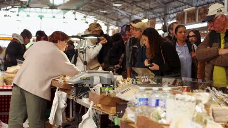 Bustling-market-scene-at-Le-Marché-Provençal-in-Antibes,-shoppers-exploring-stalls