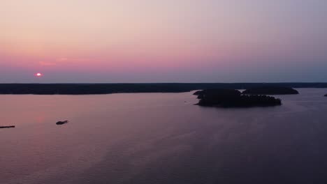 Sunset-aerial-view-of-Stockholm-Archipelago,-serene-water-and-islands-in-pink-hues