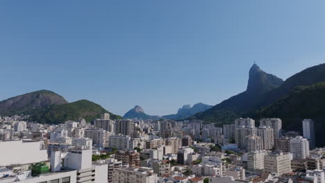 Slow-aerial-flyover-of-the-apartment-buildings-of-Botafogo-in-Rio-de-Janeiro,-Brazil-with-Christ-the-Redeemer-statue-in-the-background