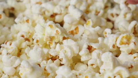 Close-Up-Of-Hand-Grabbing-Taking-Popcorn-Snack-From-The-Pile