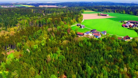 Aerial-View-of-Scenic-Countryside-Village-Surrounded-by-Green-Forest-and-Fields