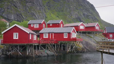 Tilt-down-reveal-footage-of-the-red-rorbu-houses-in-the-beautiful-fisher-village-of-Å-in-the-Lofoten-Islands,-Norway