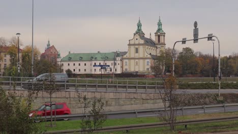 Tráfico-De-Vehículos-En-Cámara-Lenta-Cerca-De-La-Iglesia-En-Cracovia,-Polonia