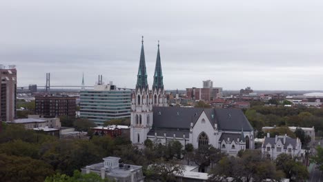 Wide-aerial-push-in-shot-of-the-historic-Cathedral-Basilica-of-Saint-John-the-Baptist-in-Savannah,-Georgia