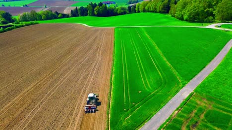 Luftaufnahme-Eines-Traktors,-Der-Felder-Mit-Grünem-Und-Braunem-Ackerland-Pflügt