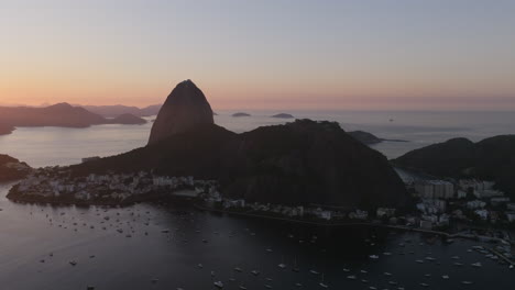 Imágenes-Aéreas-Que-Se-Mueven-Lentamente-Hacia-La-Silueta-De-La-Montaña-Pan-De-Azúcar-Durante-El-Amanecer-En-Río-De-Janeiro,-Brasil