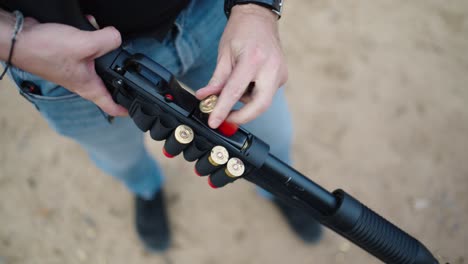 Person-reload-new-shells-into-shotgun-weapon,-Olesko-shooting-range