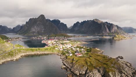 Aerial-push-out-revealing-the-beautiful-city-of-Reine-in-the-sunlight,-Lofoten-Islands,-Norway