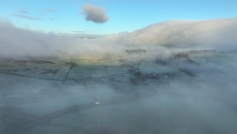 Misty-landscape-with-mountain-covered-in-flowing-cloud-at-dawn-in-winter