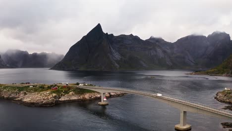 Aerial-view-of-a-white-campervan-crossing-the-Hamnøy-bridge-near-Reine,-Lofoten-Islands,-Norway