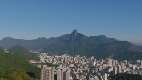 Zeitlupen-Luftaufnahmen-Von-Geiervögeln,-Die-über-Einem-Berg-In-Rio-De-Janeiro-Fliegen,-Mit-Botafogo-Und-Christus-Dem-Erlöser-Im-Hintergrund