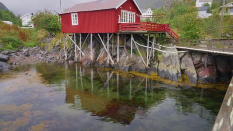 Nach-Oben-Schwenken-Und-Aufnahmen-Der-Roten-Rorbu-Häuser-Im-Wunderschönen-Fischerdorf-Å-Auf-Den-Lofoten-Inseln,-Norwegen,-Zeigen