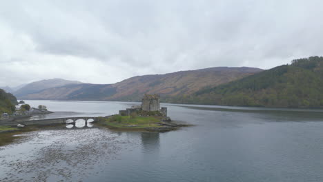 Eilean-Donan-Castle,-Umgeben-Von-Malerischen-Schottischen-Highlands-Und-Einem-Nebligen-See