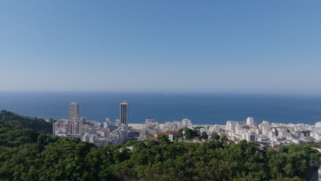 Imágenes-Aéreas-Volando-Hacia-La-Playa-De-Copacabana-Con-Una-Montaña-En-Primer-Plano-En-Río-De-Janeiro,-Brasil