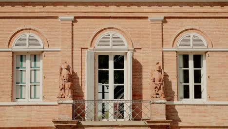 Historic-brick-building-facade-with-arched-windows-and-balcony