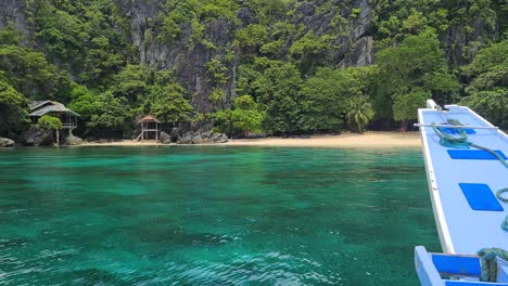 Boot-Kommt-An-Einem-Exotischen-Tropischen-Strand-Mit-Verlassenem-Haus-Unter-Steilen-Kalksteinfelsen-An