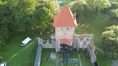 Medieval-Chudow-castle-with-a-walls,-tower,-and-courtyard-during-a-beautiful-summer-day-surrounded-by-lush-greenery,-and-trees
