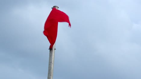 Una-Bandera-Roja-Ondea-En-El-Viento-Indicando-Olas-Peligrosas-En-La-Playa-De-Florida