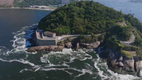 Imágenes-Aéreas-Girando-Alrededor-Del-Museo-Histórico-De-La-Fortaleza-De-São-João-En-Río-De-Janeiro-Con-Las-Olas-Del-Océano-Chocando-Contra-Las-Rocas.