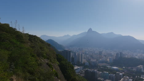 Eine-Gruppe-Von-Vögeln,-Die-Im-Kreis-Fliegen,-Mit-Der-Christusstatue-Im-Hintergrund-Im-Dunst-Von-Rio-De-Janeiro