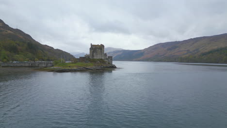 Eilean-Donan-Castle-on-a-misty-day,-surrounded-by-water-and-mountains-in-Scotland
