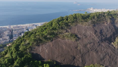 Schnelle-Luftaufnahmen-über-Den-Bäumen-Eines-Berges,-Um-Die-Nachbarschaft-Und-Den-Strand-Von-Copacabana-In-Rio-De-Janeiro,-Brasilien-Zu-Zeigen