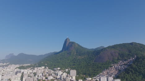 Aerial-footage-in-Botafogo-in-Rio-de-Janeiro,-Brazil-panning-across-a-favela-and-Christ-the-Redeemer-statue
