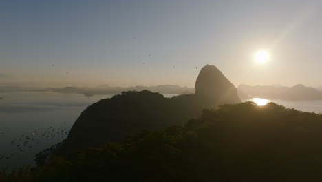 Wide-aerial-footage-during-sunrise-rotating-around-Sugarloaf-Mountain-in-Rio-de-Janeiro,-Brazil
