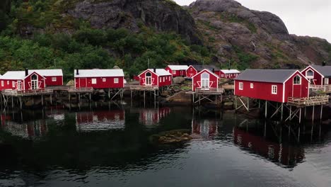 Aerial-low-flying-footage-of-the-red-rorbu-houses-in-the-beautiful-fisher-village-of-Å-in-the-Lofoten-Islands,-Norway