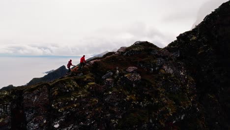 Luftaufnahme-Eines-Wanderpaares-Und-Ihres-Golden-Retriever-Hundes-Auf-Dem-Reinbringen-Wanderweg-Mit-Blick-Auf-Gylttinden,-Reine,-Lofoten-Inseln,-Norwegen