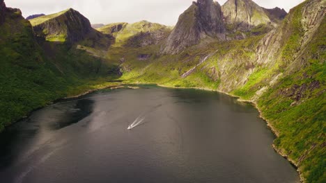 Vista-Aérea-De-Un-Barco-Que-Sale-De-Djupfjorden-Cerca-De-Reine-En-Las-Islas-Lofoten,-Noruega